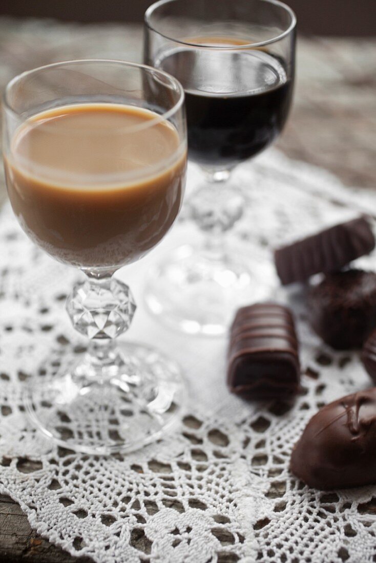 A glass of Baileys and one of Kahlua with assorted filled chocolates to one side