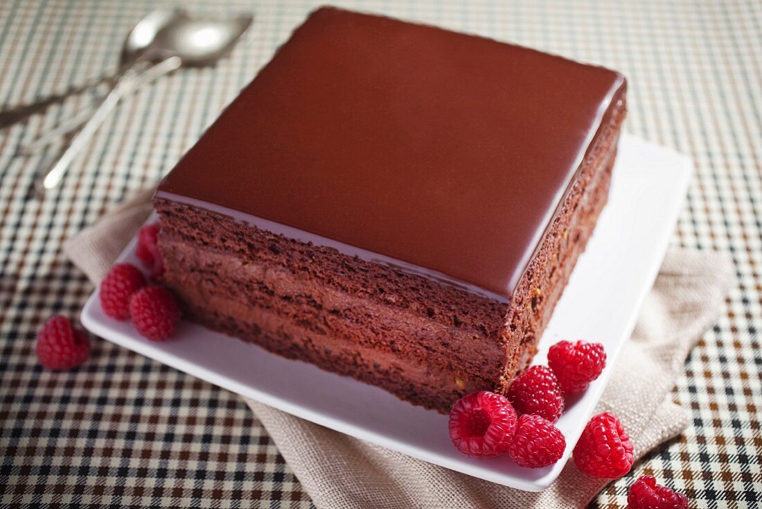 A slice of chocolate cake with fresh raspberries
