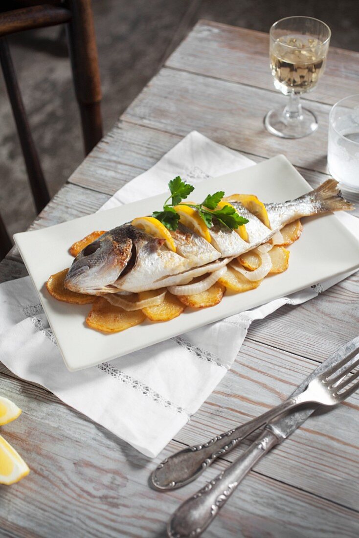 Gegrillte Dorade mit Orangen auf Kartoffelscheiben