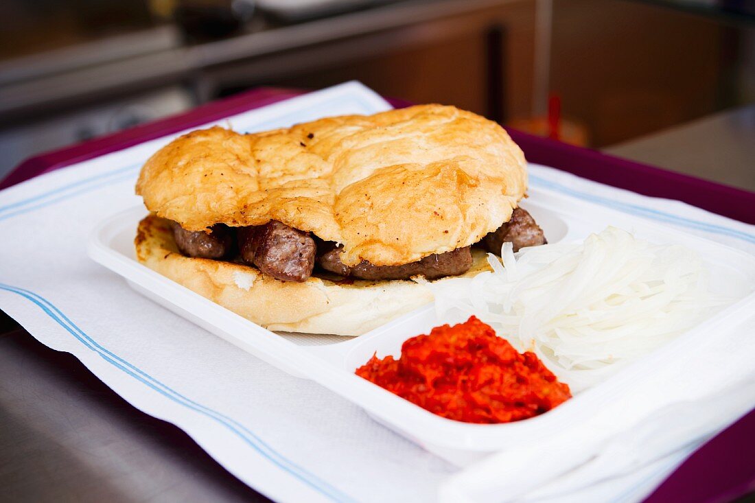 Cevapcici in flatbread with onions and ajvar