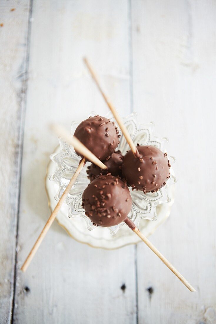 Chocolate lollies with chopped nuts in a dessert glass