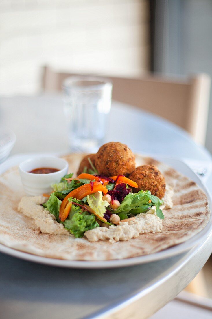 Falafels with chickpea purée and salad on flatbread