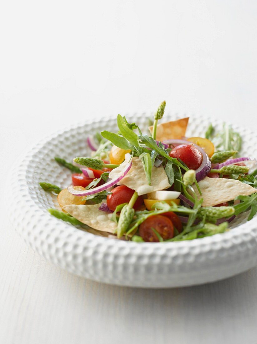 Wild asparagus salad with strudel chips, cherry tomatoes and onions