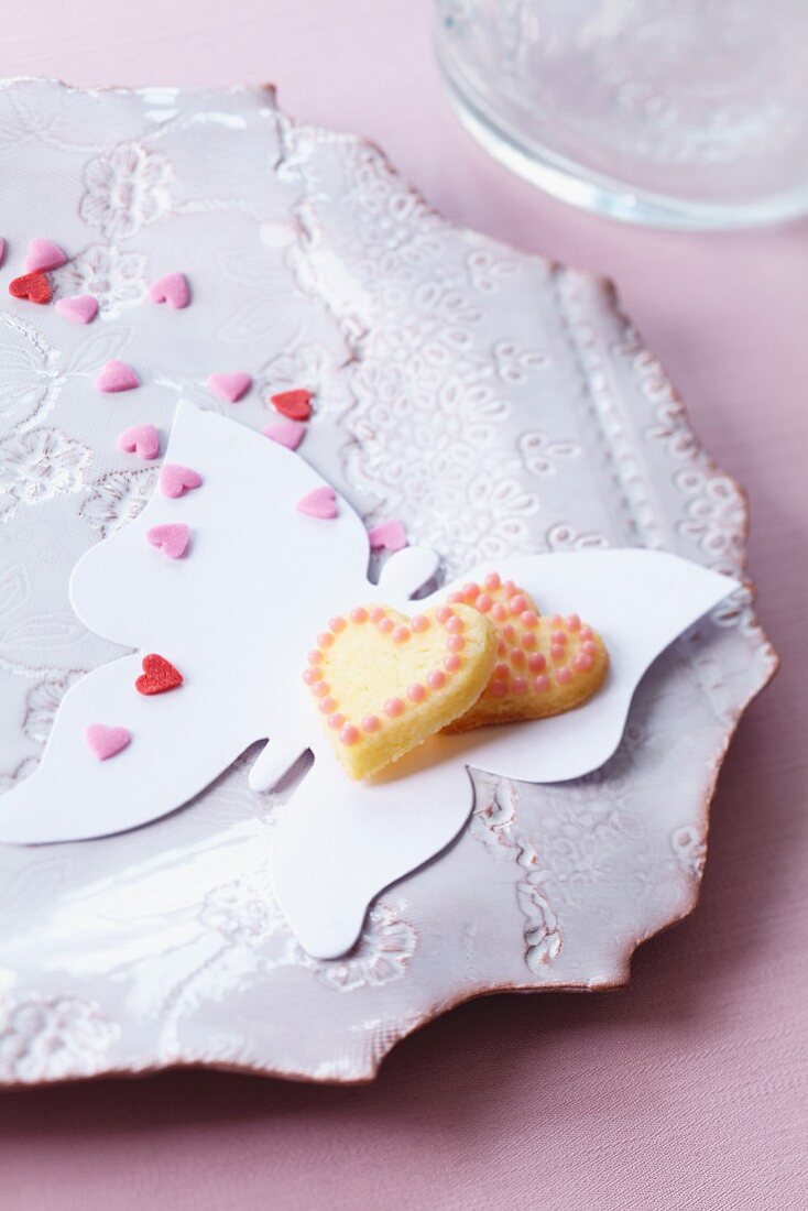 Heart-shaped biscuits and sugar hearts on paper butterfly