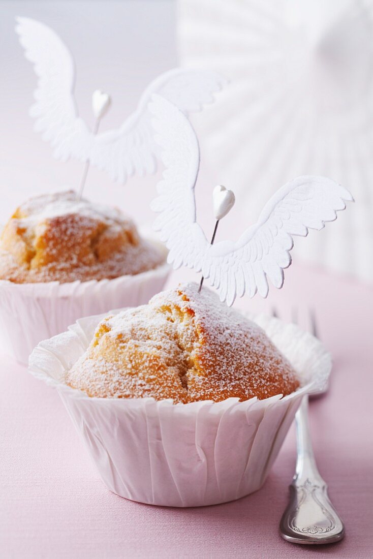 Muffins mit Puderzucker und Engelsflügeln verziert