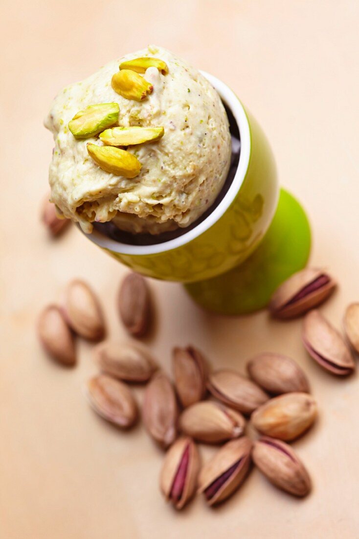 Pistachios in an eggcup with roasted pistachios to one side