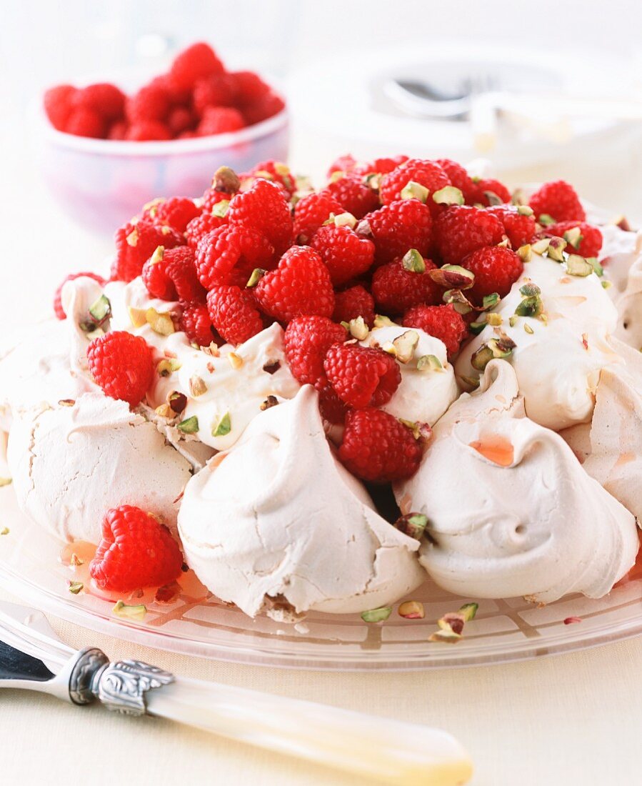 Pavlova Topped with Whipped Cream, Raspberries and Powdered Sugar