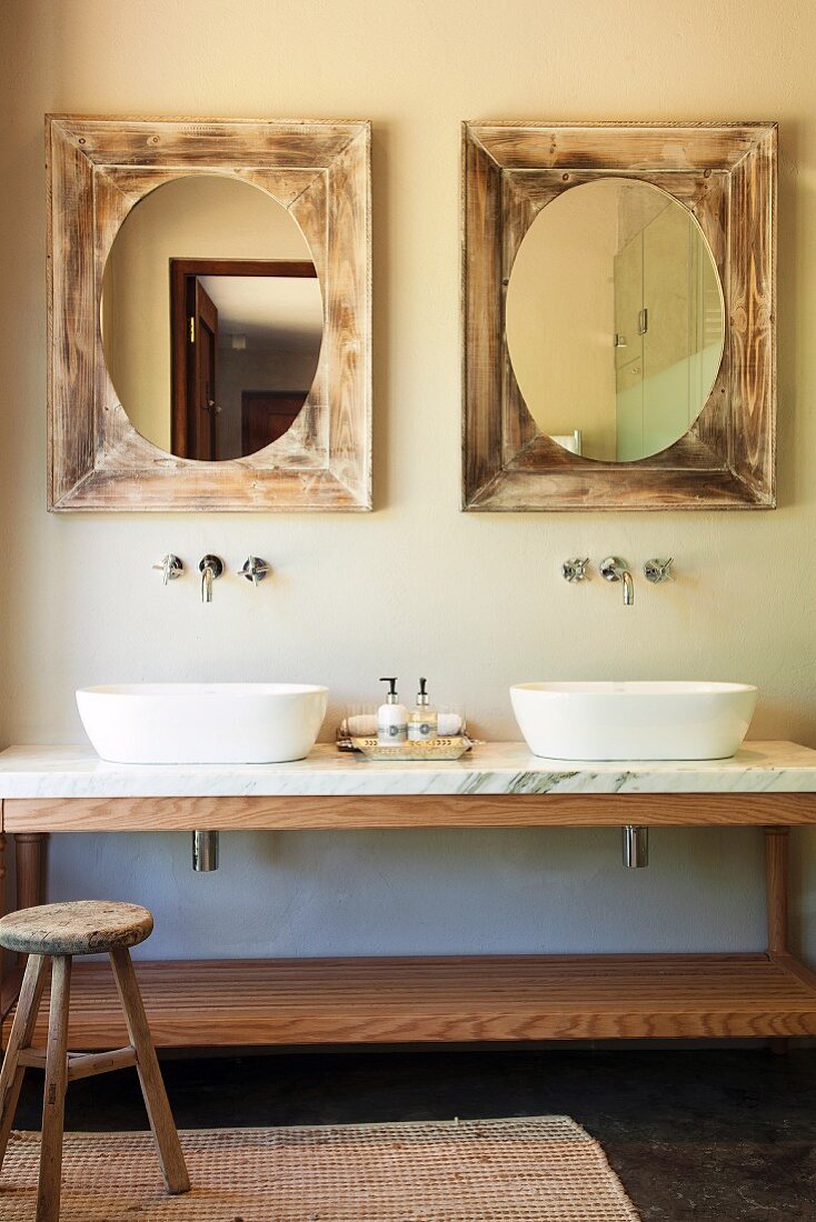 Marble washstand with twin basins below mirrors in vintage wooden frames