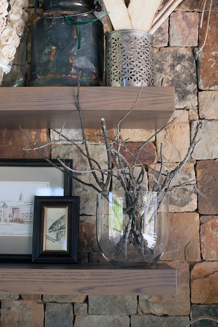 Vases and containers on wood-veneered shelves on stone wall