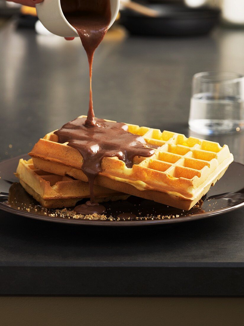 Nougat sauce being poured over waffles