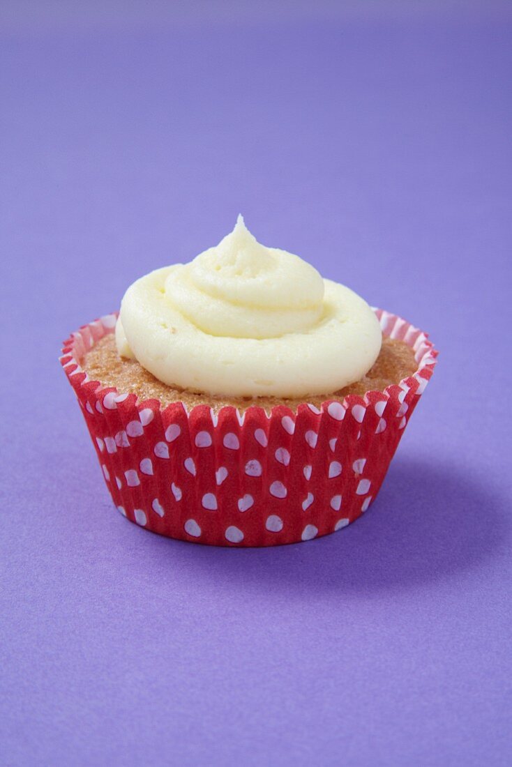 A cupcake in a red and white polka-dot paper case