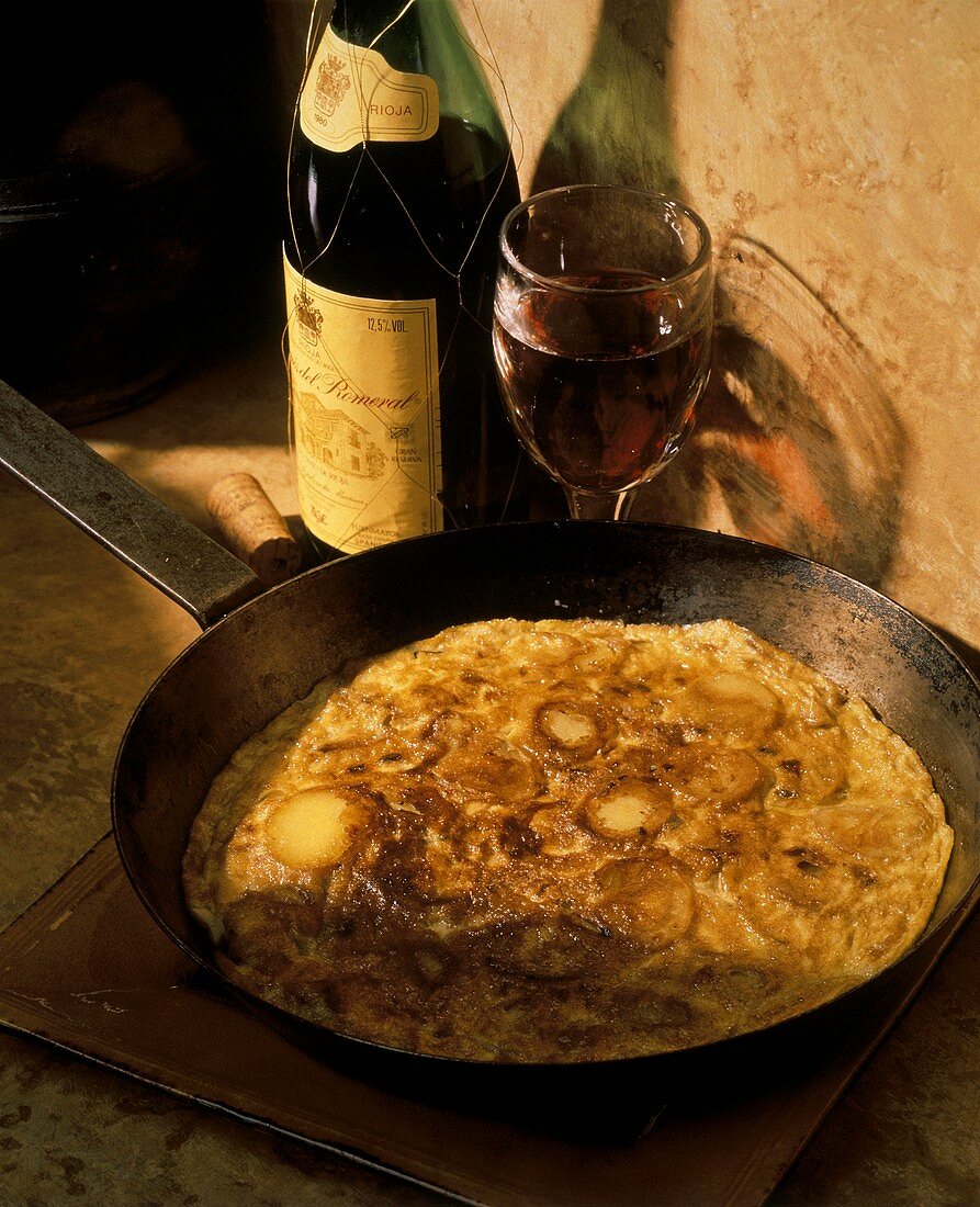 Kartoffelomelett (Tortilla de Patata) in der Pfanne, Rotwein
