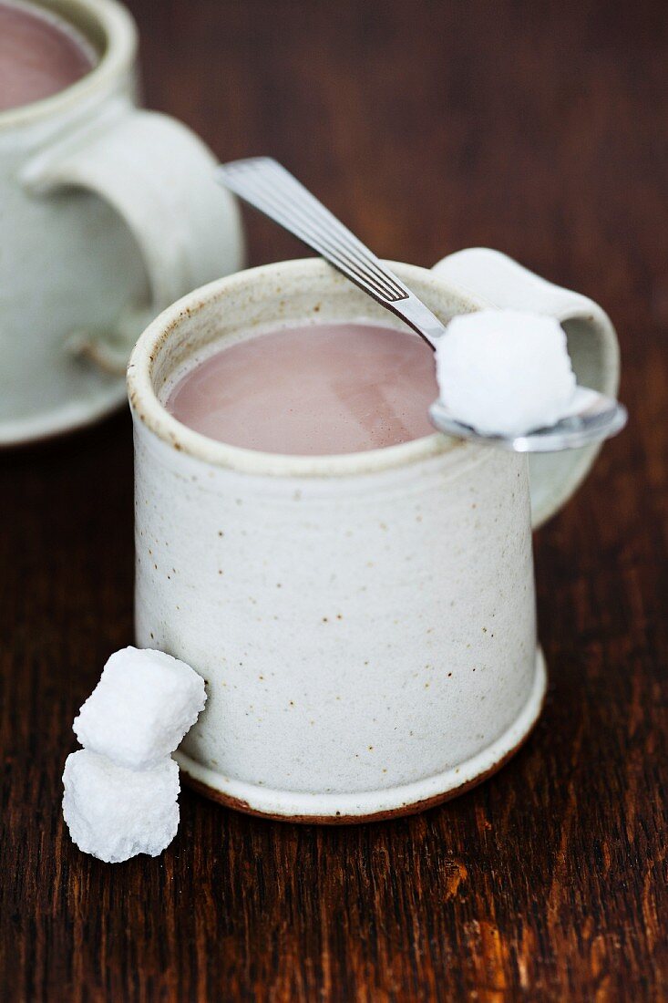 A mug of cocoa with sugar cubes