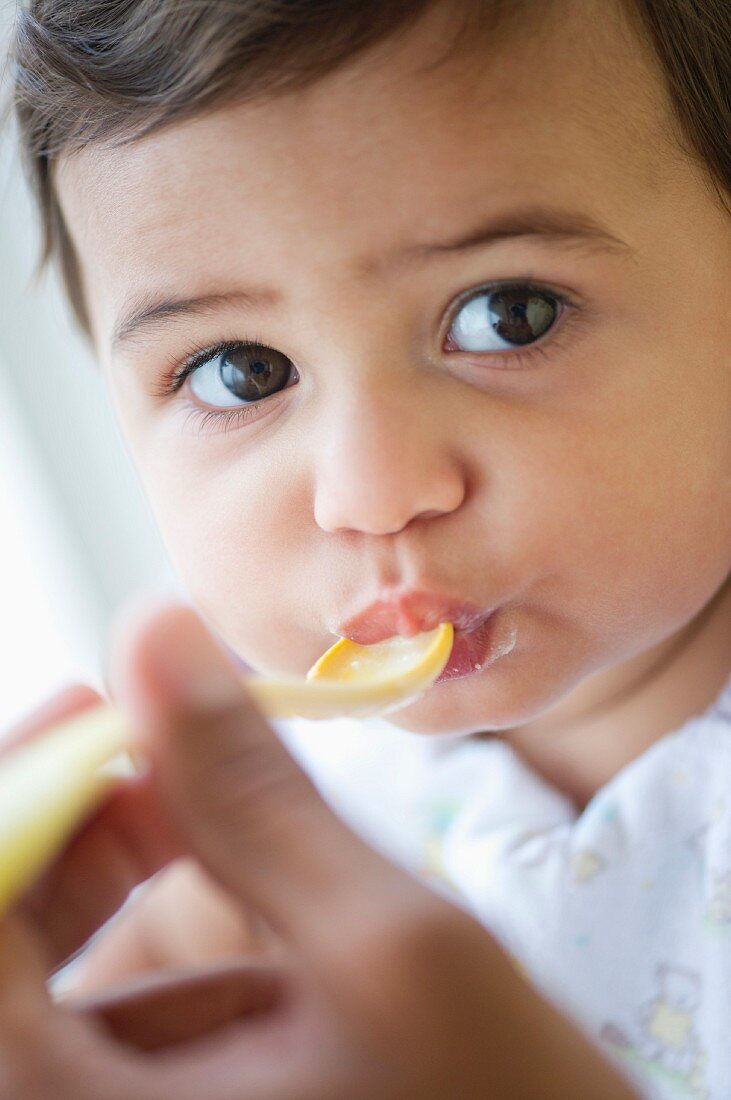 Baby isst vom Plastiklöffel