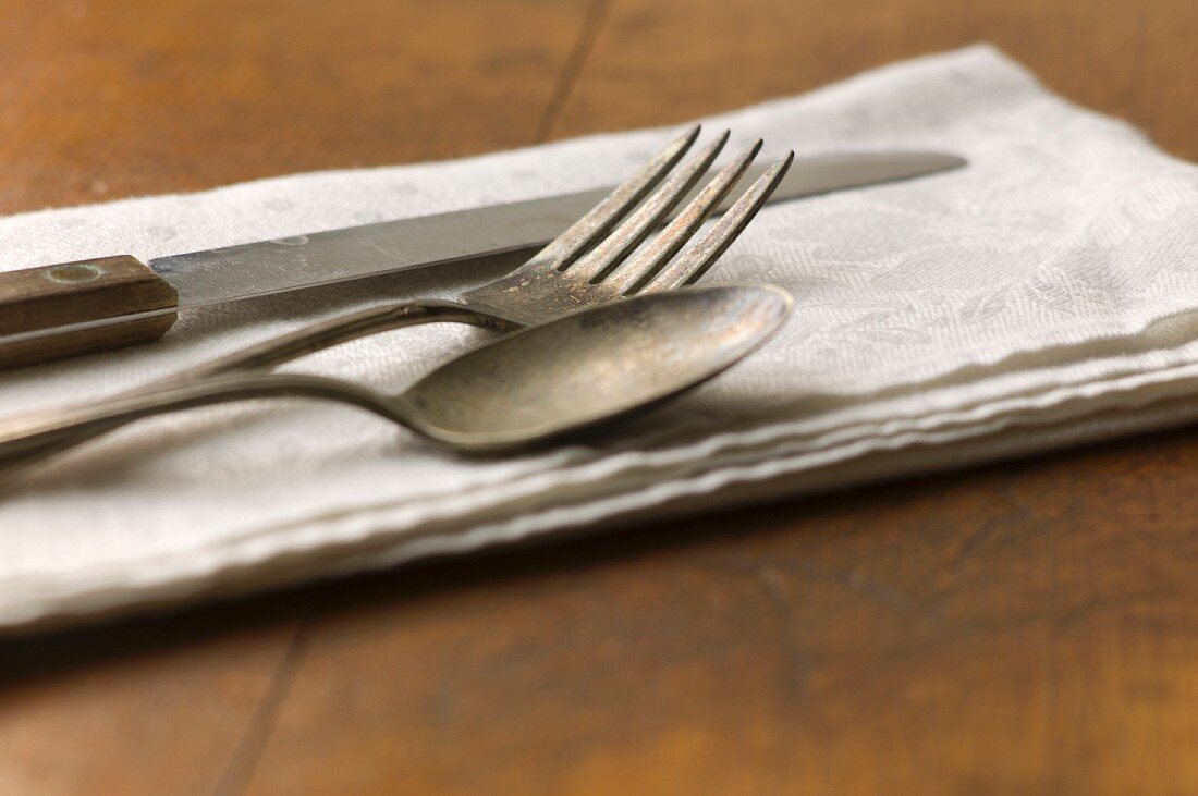Close up von Silbergabel, Messer und Löffel auf Serviette