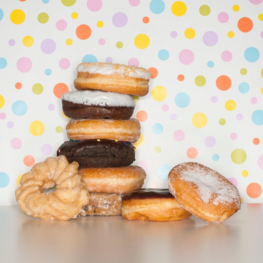 Gestapelte Doughnuts vor gepunktetem Hintergrund