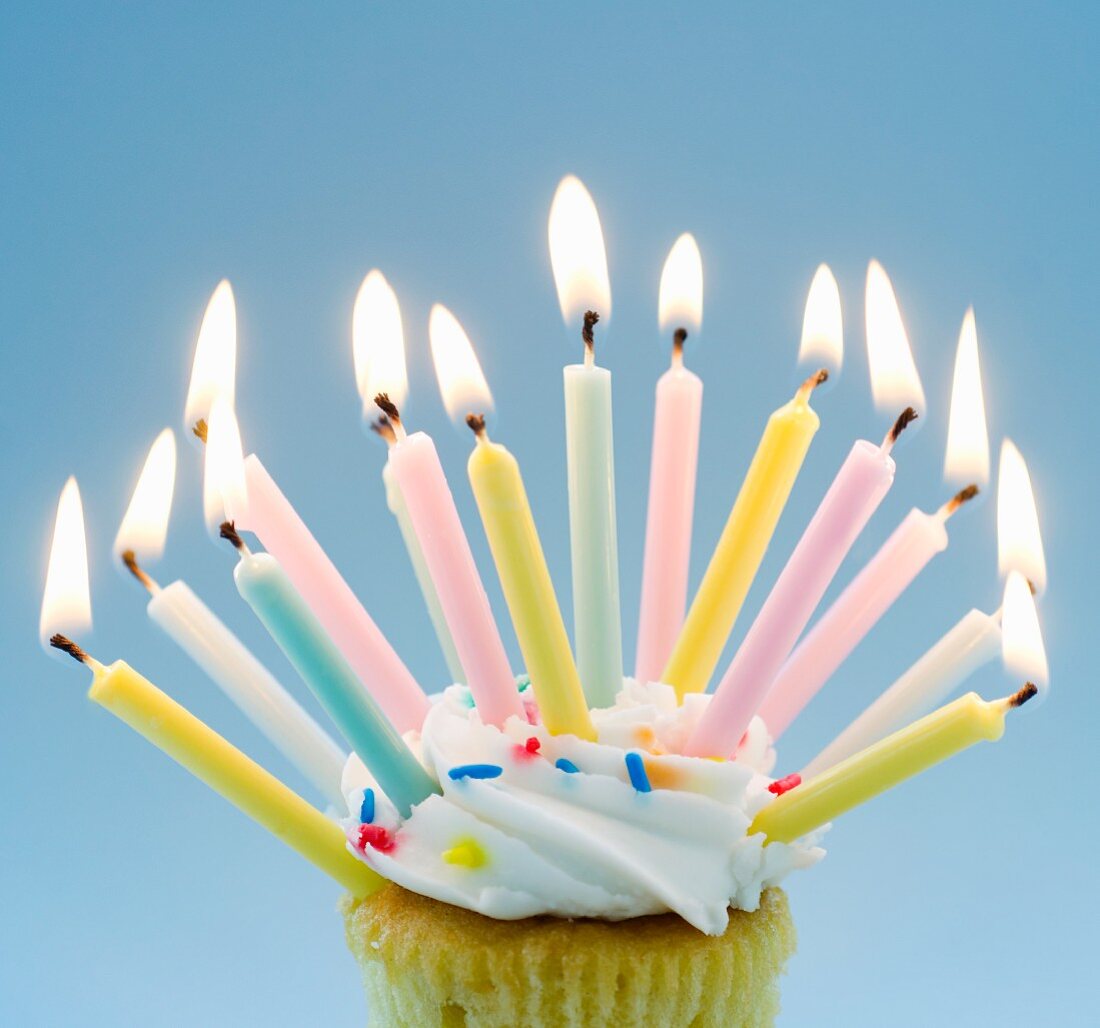 Cupcake mit vielen brennenden Geburtstagskerzen
