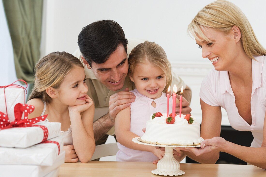 Mädchen feiert Geburtstag mit Schwester und Eltern