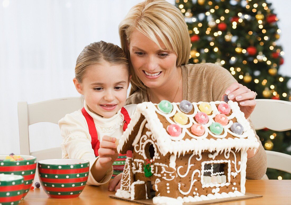Mother and daughter making gingerbread house