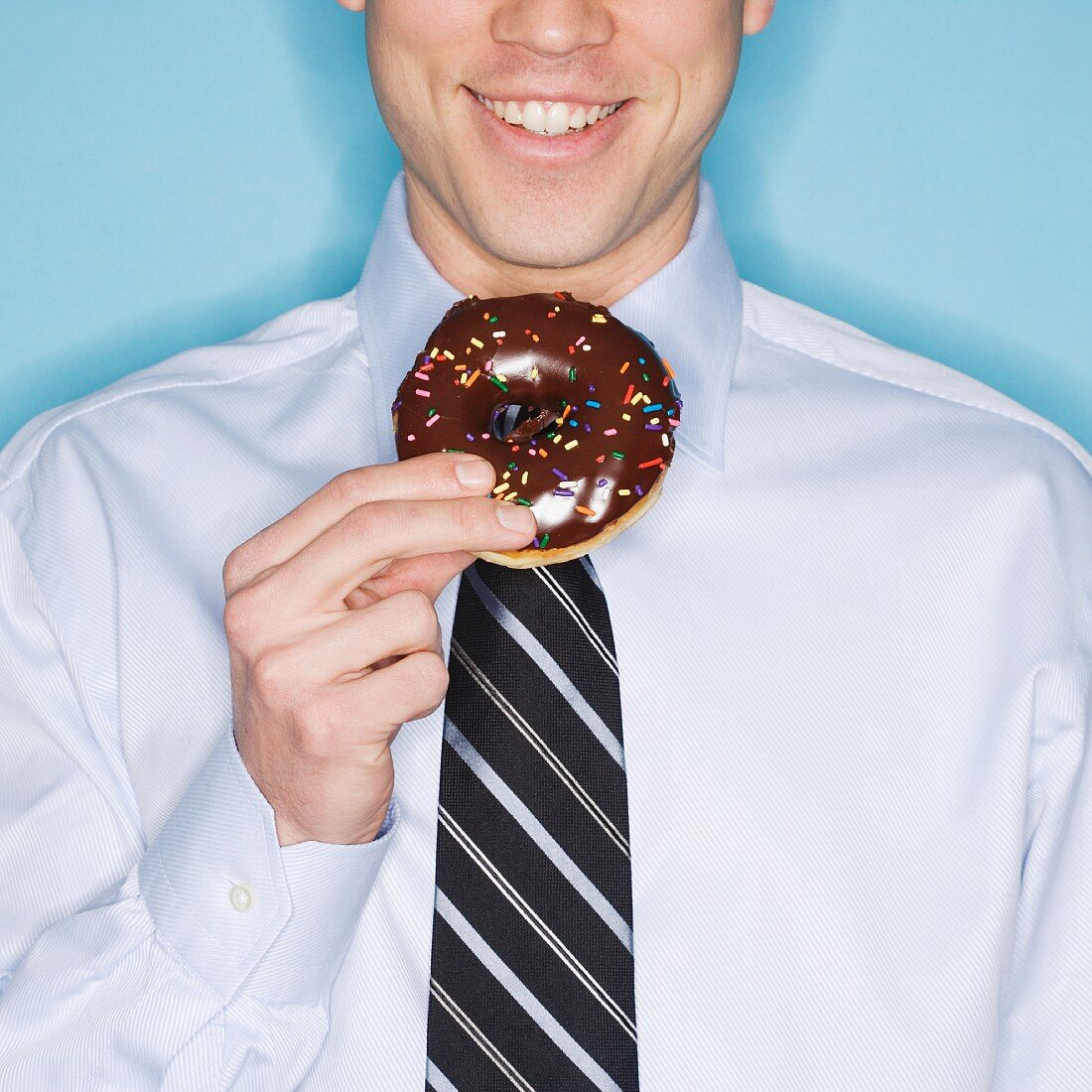 Businessman eating frosted donut