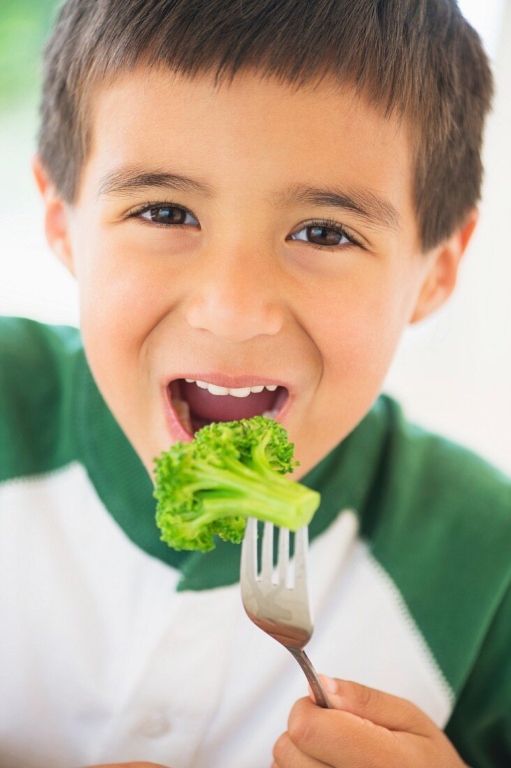 Kleiner Junge isst Brokkoli