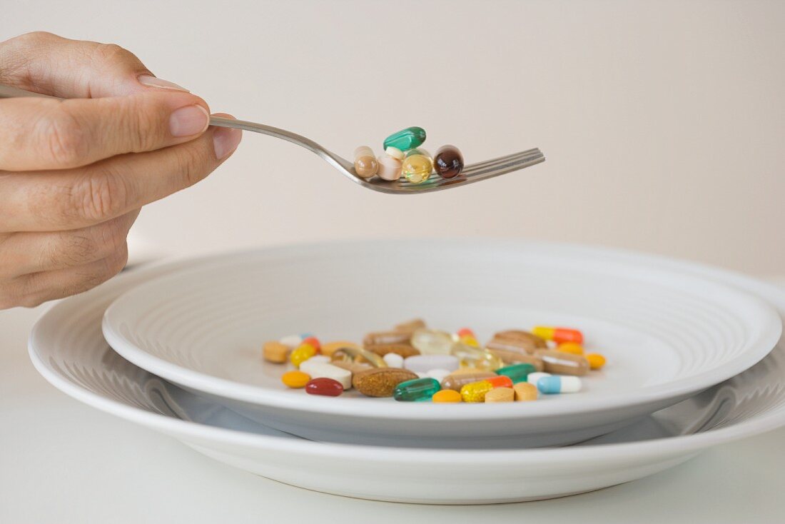 Man eating pills on fork