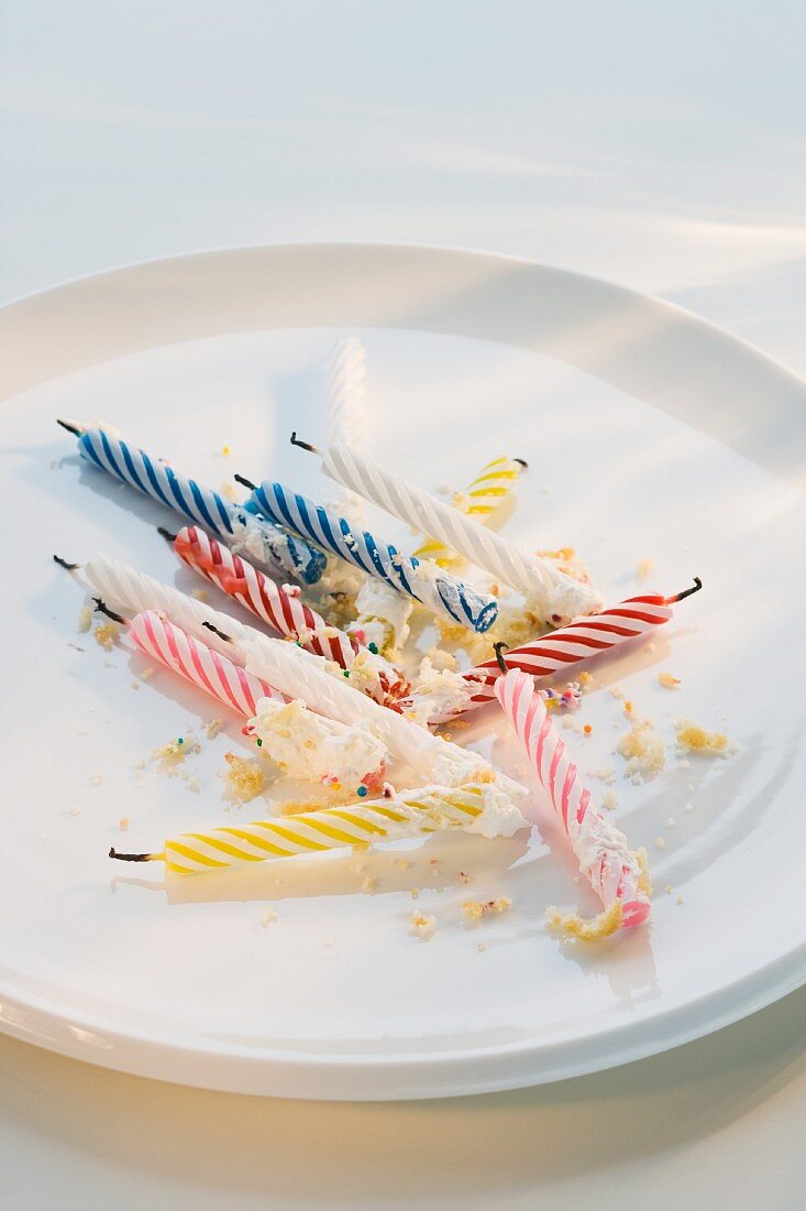 Birthday candles and crumbs on plate