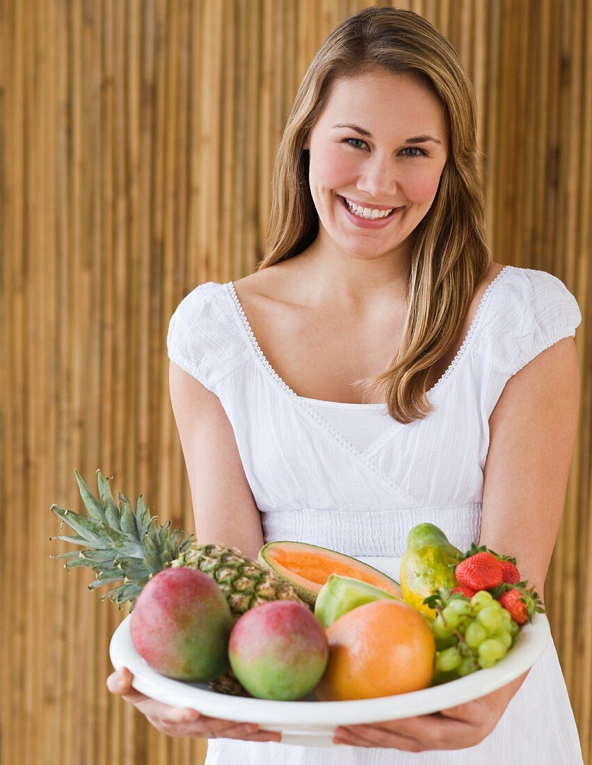 Woman holding bowl of fruit