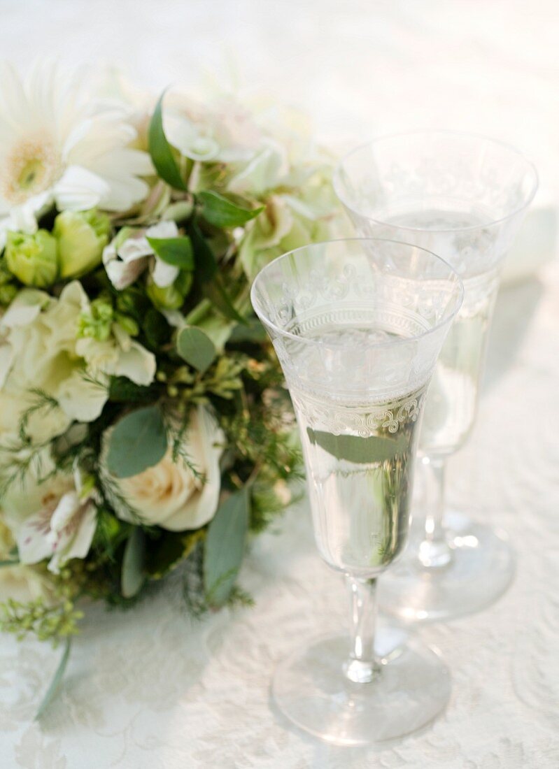 Blumenstrauß und zwei Gläser mit Champagner