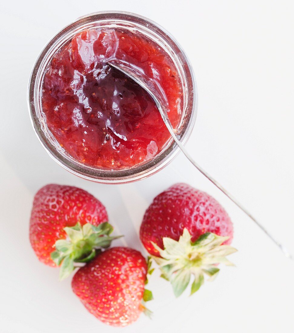 Erdbeermarmelade im Glas und frische Erdbeeren