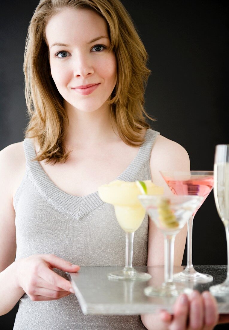 Woman holding tray of cocktails