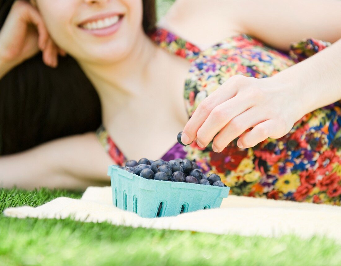 Young woman eating blueberries