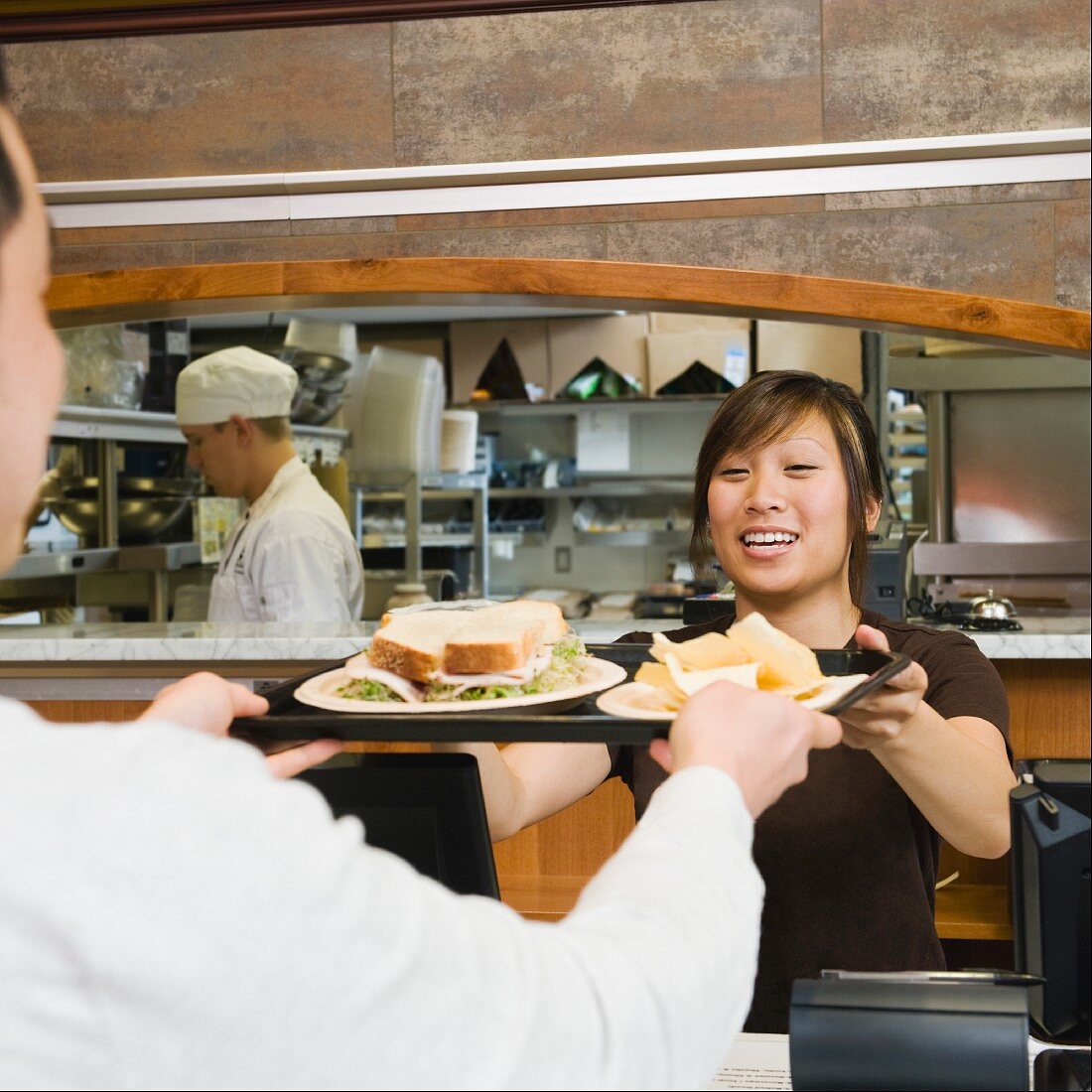 Customer receiving tray of food in bakery