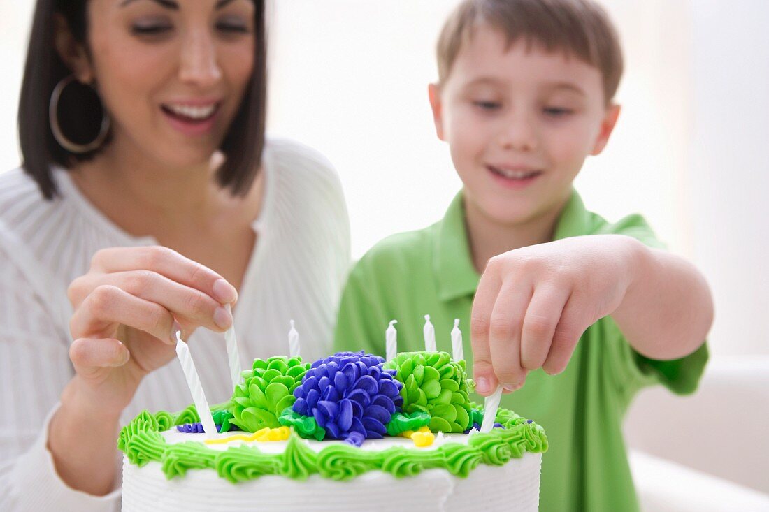 Mother and son decorating birthday cake