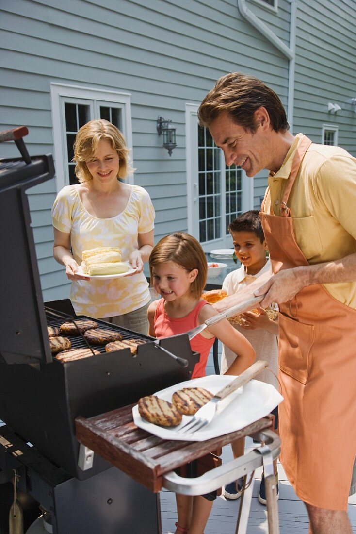 Familie beim Grillen auf Terrasse