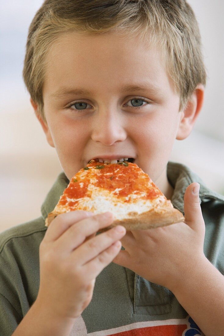 Kleiner Junge beim Pizza essen