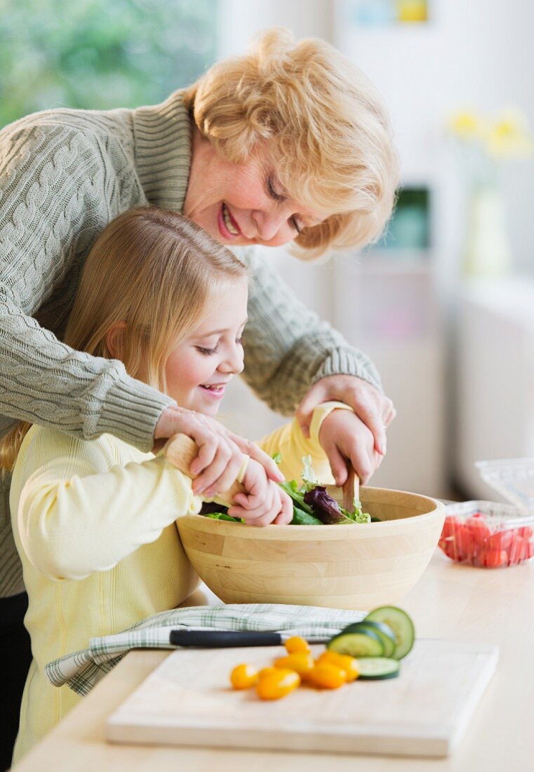 Großmutter und Enkelin bereiten den Salat zusammen zu