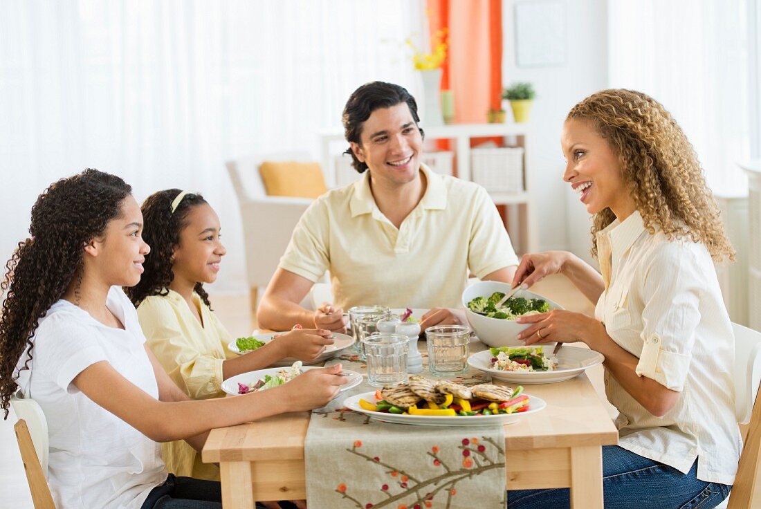 Parents with daughters (10-13) eating dinner