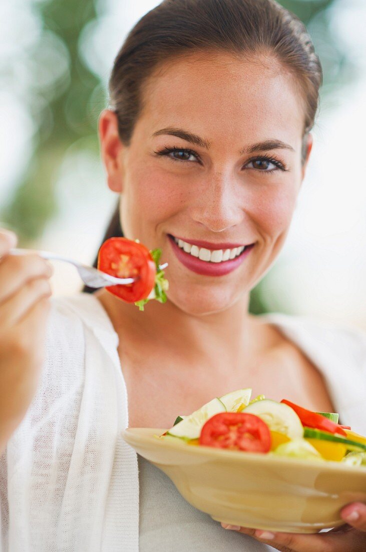 Portrait of young woman eating salad