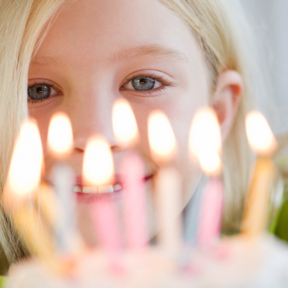 Junges Mädchen vor Geburtstagskuchen mit Kerzen