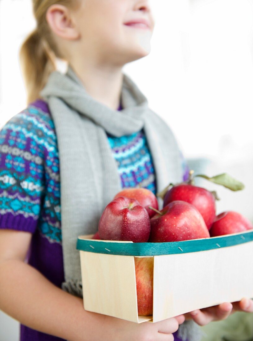 USA, New Jersey, Jersey City, Girl (8-9) holding box of apples