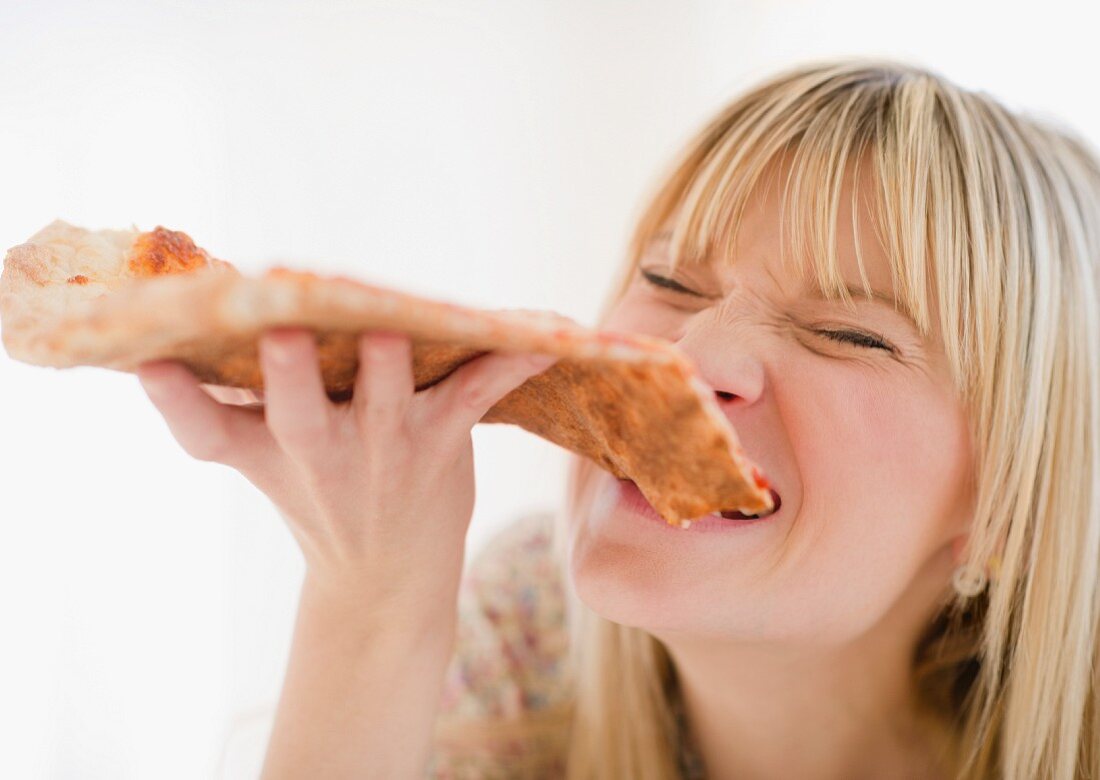 Young woman eating pizza