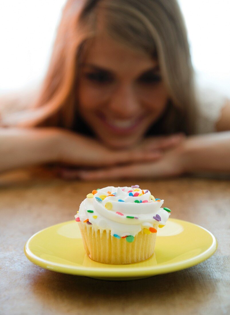 Frau betrachtet einen Cupcake