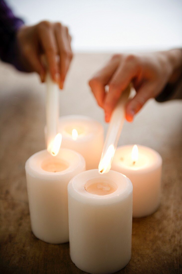 Close up of man's and woman's hands igniting candles