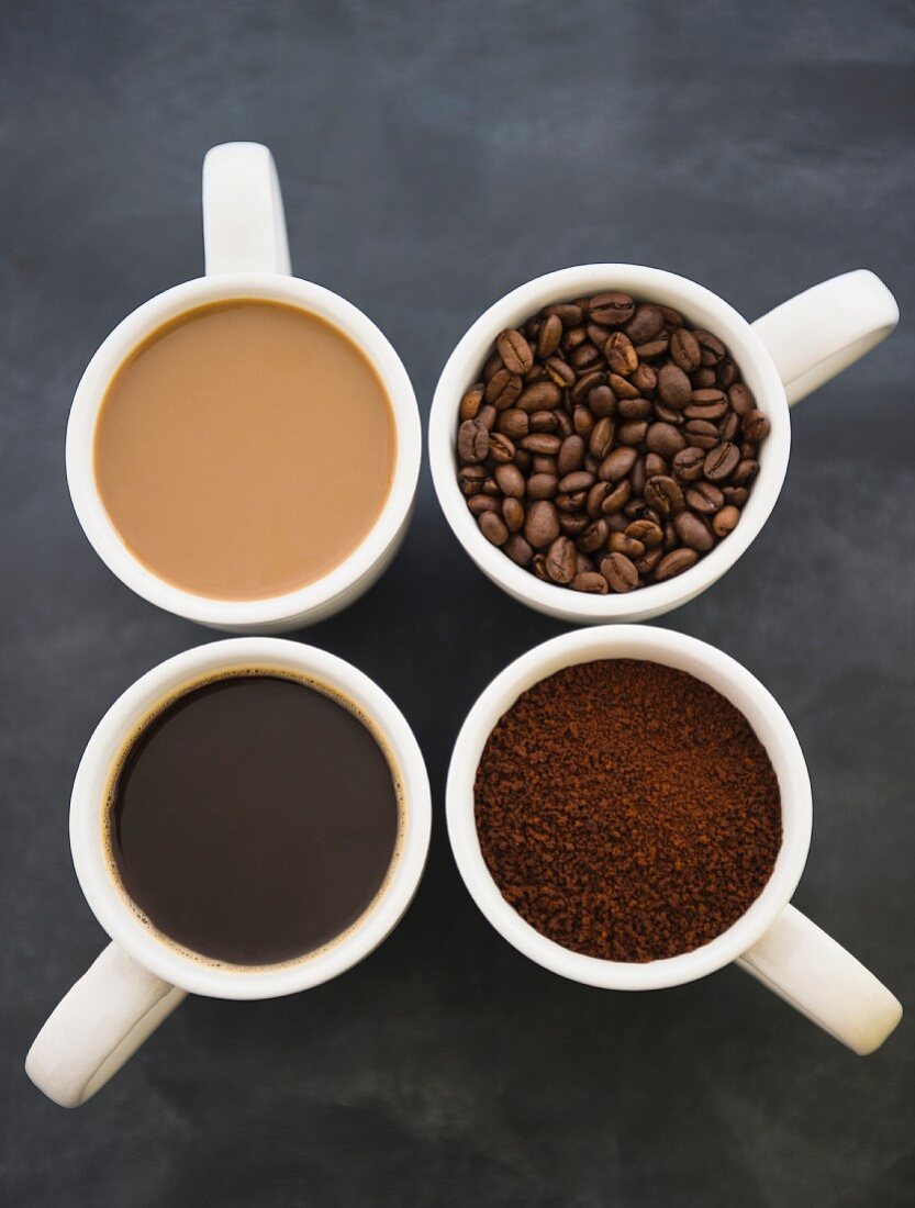 Kaffeetassen mit Kaffee und gerösteten Kaffeebohnen