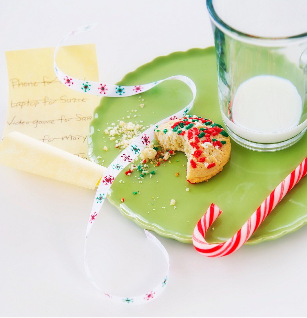 Weihnachtsstillleben mit Cookie, Zuckerstange, Milch und Wunschliste