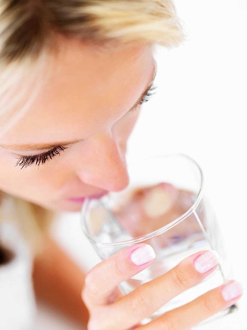 Blonde Frau trinkt ein Glas Wasser