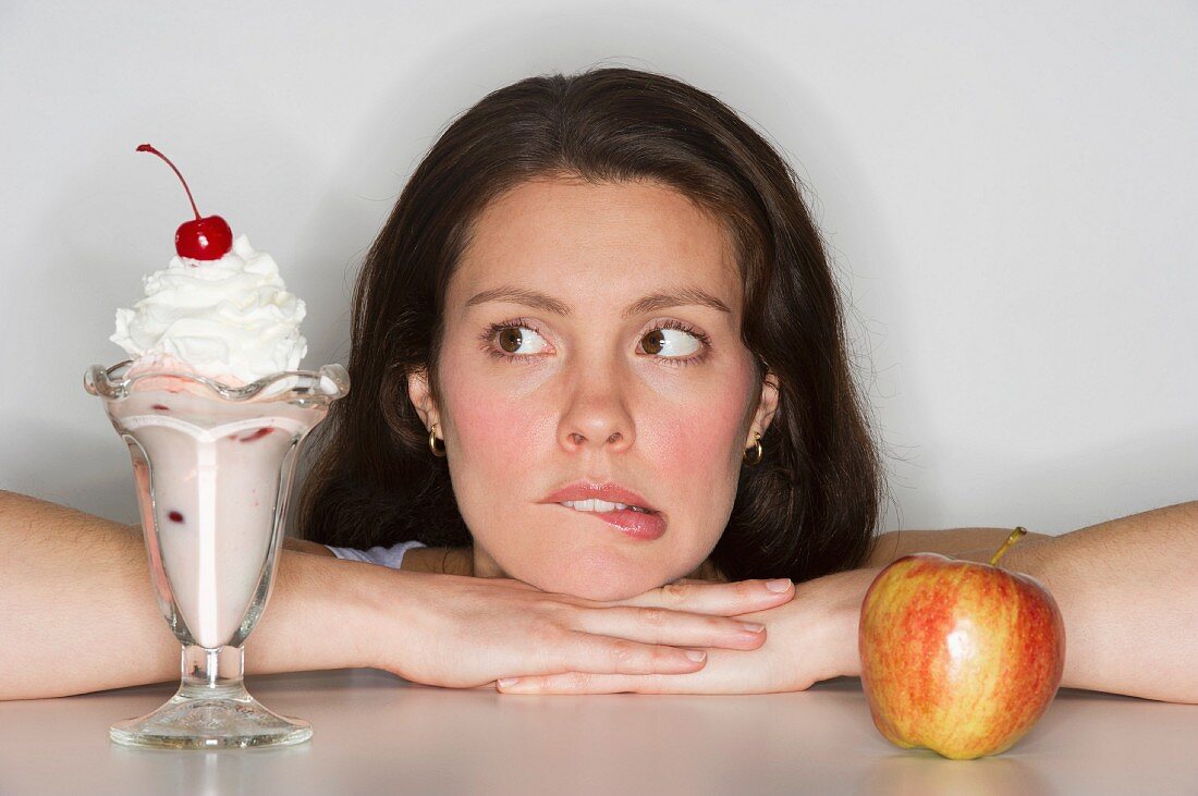 Woman choosing between ice cream and apple