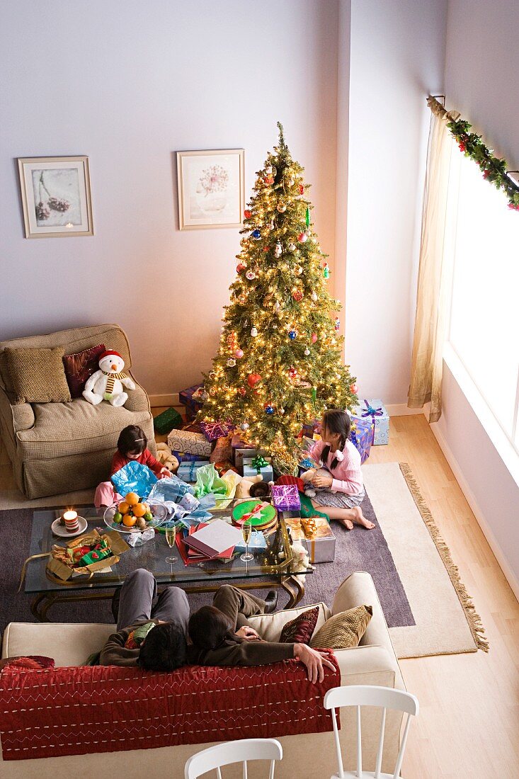 Familie mit zwei Töchtern am Weihnachtsmorgen