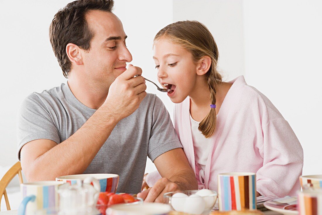 Father with daughter having breakfast
